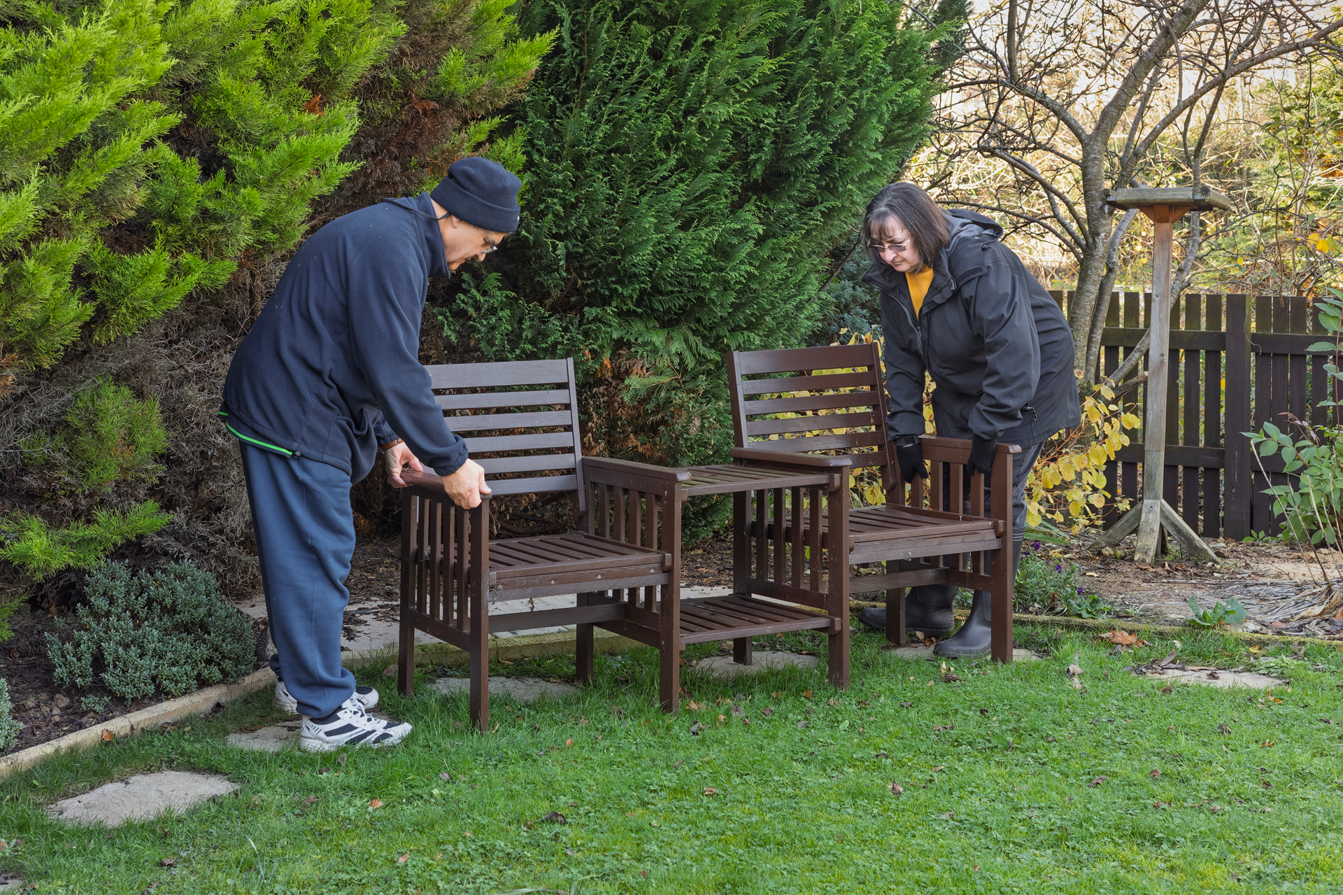 senior spring maintenance husband and wife putting out lawn furniture for spring